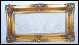 A large ornate gilt framed plaque of Diana the Huntress in relief with inset bronze medallion