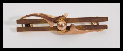 An early 20th Century hallmarked 9ct gold bar brooch having a double bar with central ball and