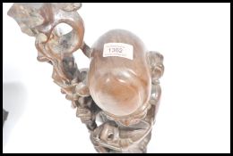 A large early 20th Century Chinese hand carved wooden figurine of an elder holding staff and peach