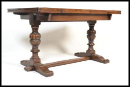 An early 20th Century oak refectory dining table in the Jacobean style raised on scrolled base