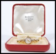 A vintage 20th Century 9ct gold ladies cocktail watch set to a 9ct gold strap. The silvered dial