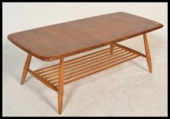 A retro 20th Century Ercol Golden Dawn beech and elm coffee table raised on tapering supports united