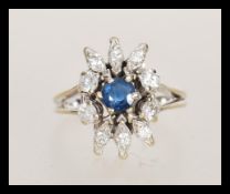 An 18ct white gold ring sapphire and diamond cluster ring having a central round cut sapphire