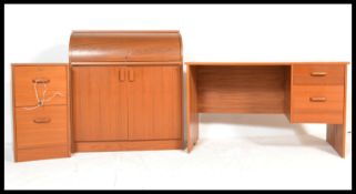 A 1970's retro mid 20th century teak office suite comprising a pedestal desk with a roll top