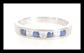 A hallmarked 9ct white gold seven stone diamond and sapphire ring having alternating blue and