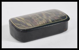 A 19th Century lacquered snuff pot of lozenge form, hinged painted lid with tortoiseshell finish.