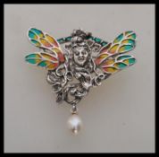 A stamped 925 silver brooch in the form of a fairy having coloured plique a jour wings and a pearl