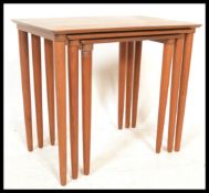 A retro Danish 1970's nest of tables consisting of three graduating tables raised on tapering