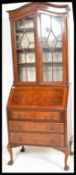 A 1940's Georgian style Regency Revival walnut bureau bookcase having twin astragal glazed doors