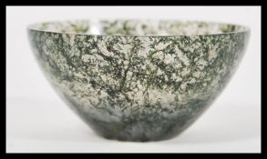 A Chinese jade tea bowl of small proportions having a clear jade body with green and white mottled