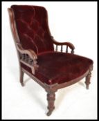 A Victorian 19th century mahogany armchair being raised on turned legs terminating in castors.