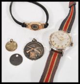 A vintage Smiths Empire shockproof 5 jewels wrist watch, having a round white face with gilt