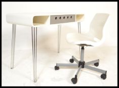 A retro contemporary white desk raised on metal hairpin legs with inset drawer. Complete with