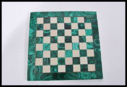A vintage green African malachite stone chess board of square form having alternating grid chess
