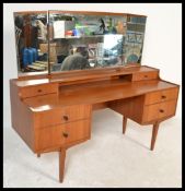 A retro 20th Century kneehole twin pedestal teak wood dressing table, triptych mirror to the top