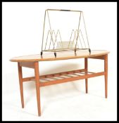 A vintage retro 20th century occasional coffee table raised on tapering legs with magazine rack