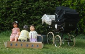 A 20th Century Silver Cross dolls pram painted black having a black canape. Along with three