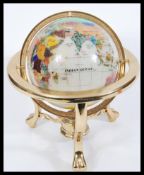 A vintage 20th Century desk top globe having a gilt brass frame with semi precious lapis lazuli