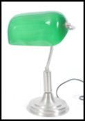 A vintage retro 20th Century bankers lamp having an adjustable green glass shade raised on stepped