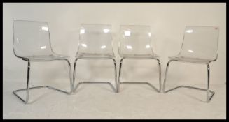 A set of four retro 20th century dining chairs, having chrome tubular frame and transparent seats