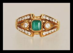A stamped 750 18ct gold ladies dress ring set with a square cut emerald within a split shank
