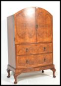 An early 20th Century walnut Queen Anne style cabinet tallboy having twin cupboard doors over two