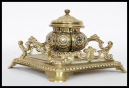 A Victorian 19th century cast brass desk capstan inkwell having twin handles with tray base, central