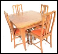 An early 20th Century Edwardian oak dining table and chairs. The table raised on tapering block legs