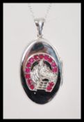A stamped 925 pendant locket having a raised horse to the front of the locket and a horseshoe set