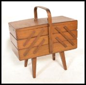 A vintage 20th Century beech wood concertina metamorphic action sewing / work box, carry handle to