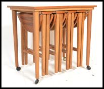 A vintage retro 20th century teak wood side table with four folding occasional / nest of four