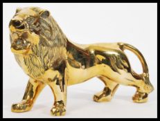 A large 20th Century heavy cast brass figurine in the form of a roaring male lion having detailed