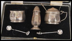 A silver hallmarked cruet set within a fitted case to include salt, pepper and mustard pot with