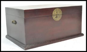 A 20th Century Chinese hardwood blanket box / chest, hinged top with brass carry handles to the side