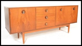 A retro 20th Century teak wood sideboard credenza having a central bank of three drawers flanked