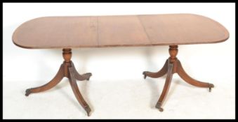 A 20th Century Edwardian Regency Revival twin pedestal extending D end dining table, inlaid with