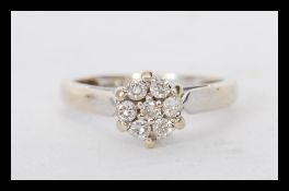 A hallmarked 18ct gold diamond cluster ring having a cluster of seven stones to the head. Hallmarked