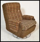 A vintage retro 20th Century woolen upholstered revolving easy / armchair, raised on a circular