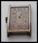 An early 20th Century Rolex tank watch having a silvered dial of square form. The case and
