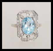 A stamped 925 silver panel ring set with a large oval cut topaz set with cz accent stones to the