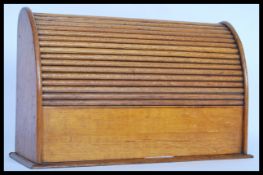 A 1920's golden oak stationary desk top tidy,tambour front opening to reveal a fully appointed