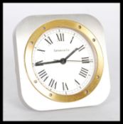 A Tiffany and Co travelling desk easel clock of square form having a gilt rim with Roman numeral