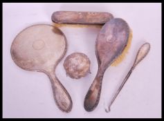 An early 20th Century silver hallmarked dressing table set consisting of hand held mirror, clothes