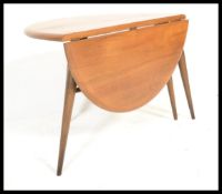 An Ercol retro 1970's drop leaf circular coffee - occasional table by Ercol raised on tapered legs