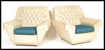 A pair of vintage retro 20th Century arm chairs armchairs of Chesterfield type having button backs