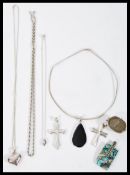 A selection of silver necklaces to include two crucifix pendants, a heart pendant necklace, a