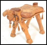 A 20th century Camel stool having a hard wood frame with brass work decoration. Measures 40 cm
