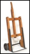 An early 20th century industrial factory workmans barrel push sack truck trolley, having an oak wood