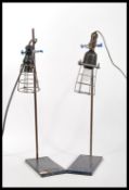 A pair of vintage retro 20th Century inspection lamps having wire cages mounted on Griffin and