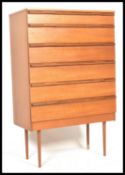 A retro 20th Century teak wood chest of drawers, having six drawers with shaped recessed handles.